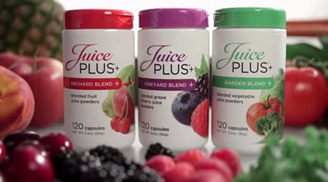 An image of Juice Plus products surrounded by fruits and vegetables. 